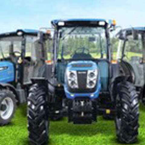 Blue Solis tractors lined up in a field under clear skies, showcasing compact utility models.