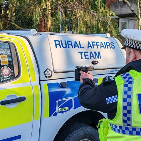 Devon & Cornwall Police officer using a handheld scanner to check vehicle identification.
