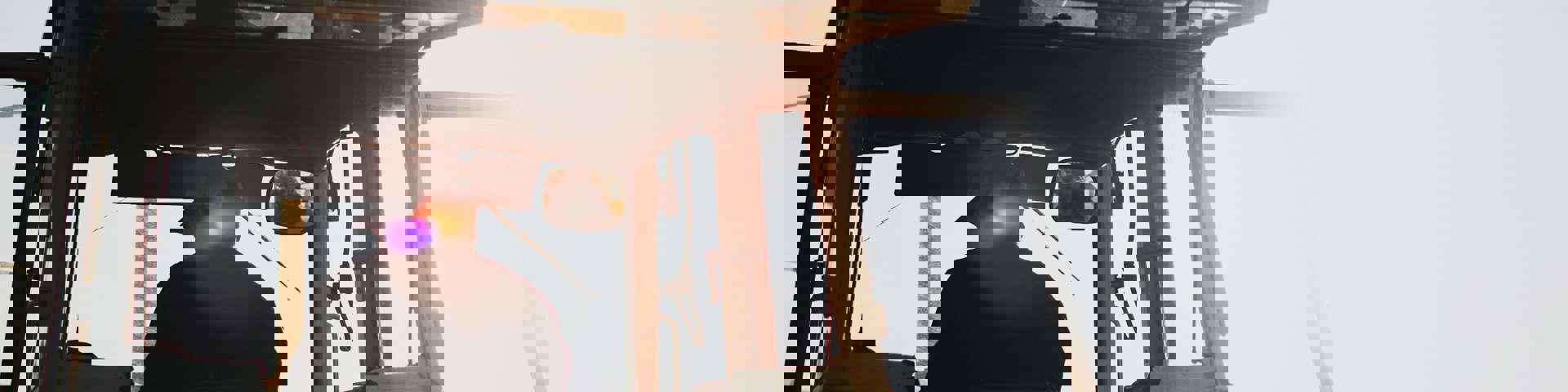 A farmer operates a tractor under clear, sunny skies.