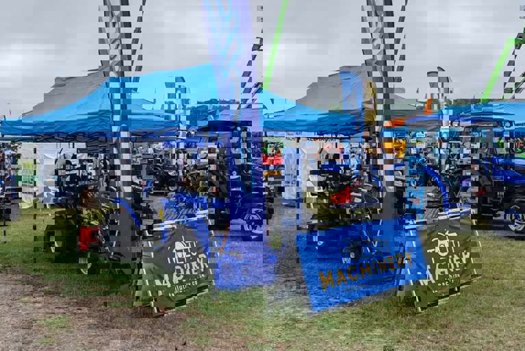 Tallut Machinery exhibition stand showcasing blue Solis tractors and equipment.