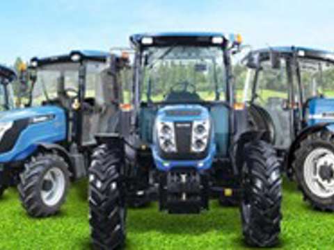 Blue Solis tractors lined up in a field under clear skies, showcasing compact utility models.