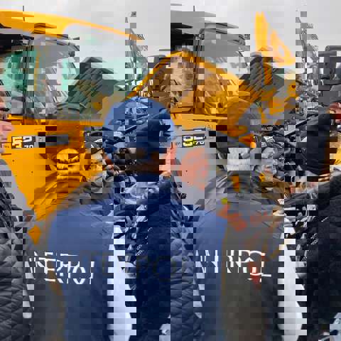 Trainer Nick Mayell providing practical training near yellow heavy plant machinery.