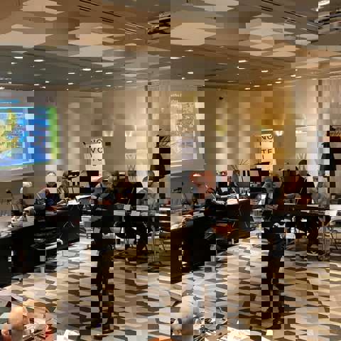 Nick Mayell leading a classroom training session with a PowerPoint presentation displayed on a screen.