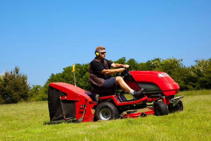 VIN Chip Protected Red Ride On Mower On A Green Field
