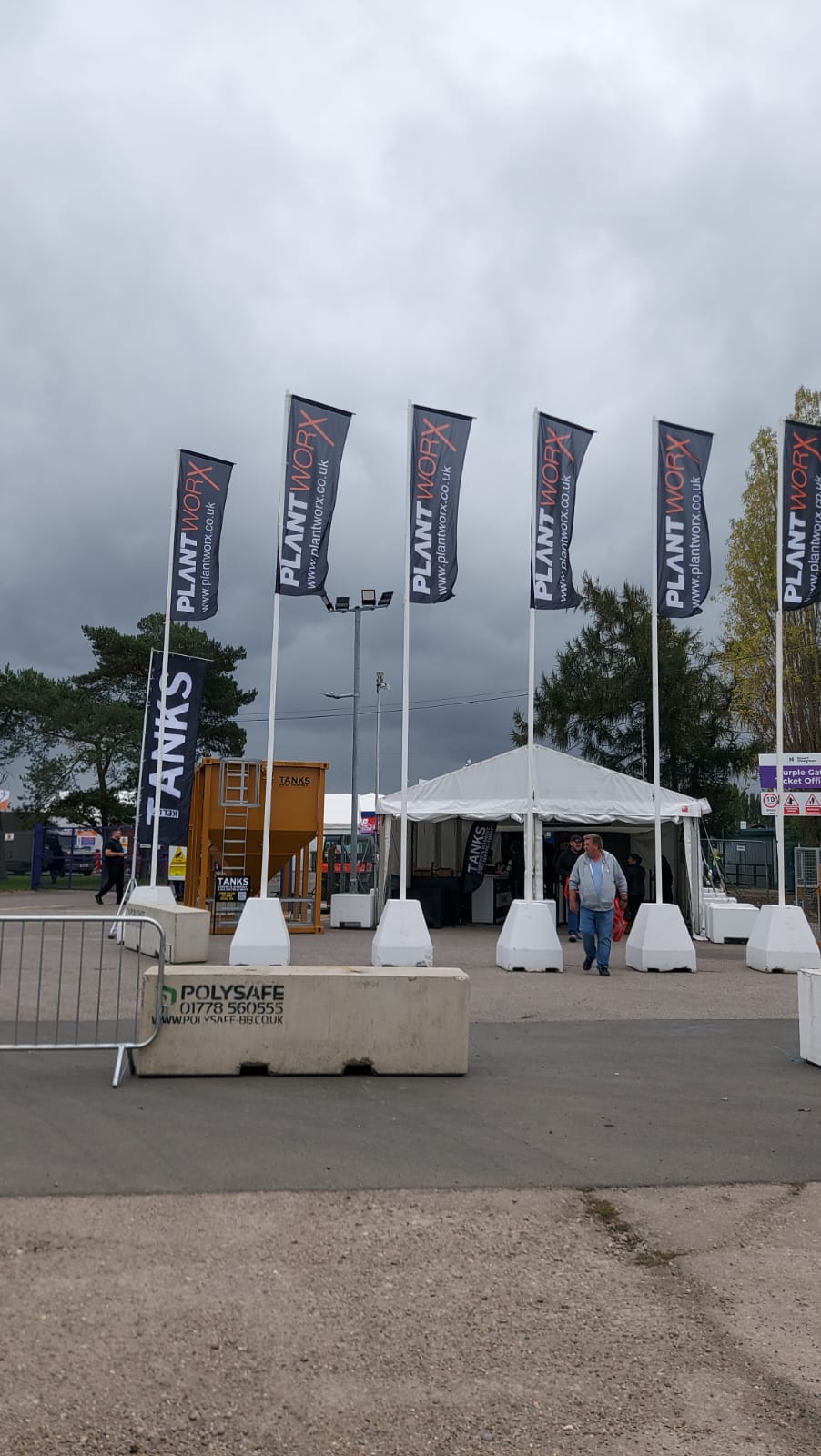 Blue PlantWorx 2025 flags at the show entrance on a cloudy day