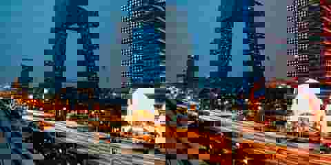 Modern cityscape at night, showcasing skyscrapers and vibrant lights.