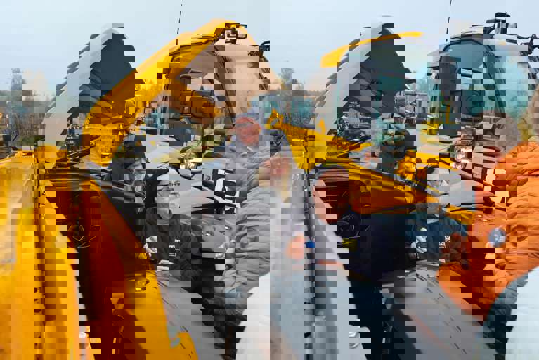 Nick Mayell instructing a group during hands-on training, all wearing winter coats and hats.