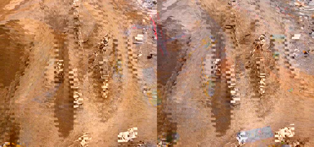 A construction site bustling with activity, featuring trucks filled with earth.