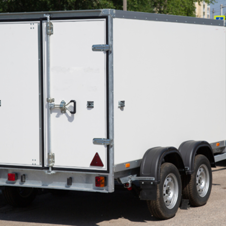 White enclosed trailer parked on the roadside.