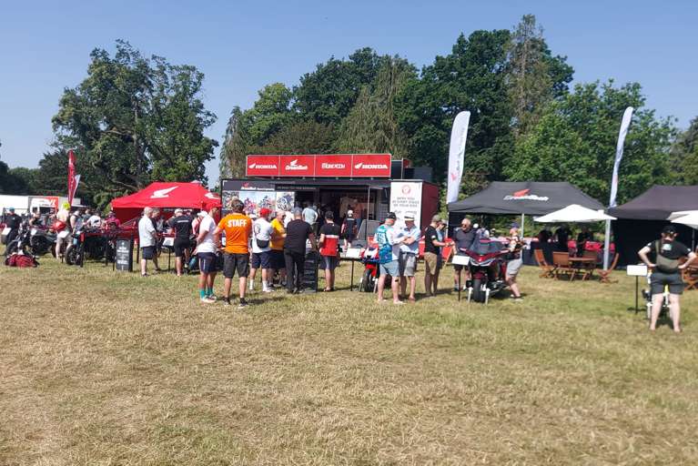 Visitors exploring motorcycle and refreshment exhibitor stands at the Adventure Bike Rider Festival 2026.