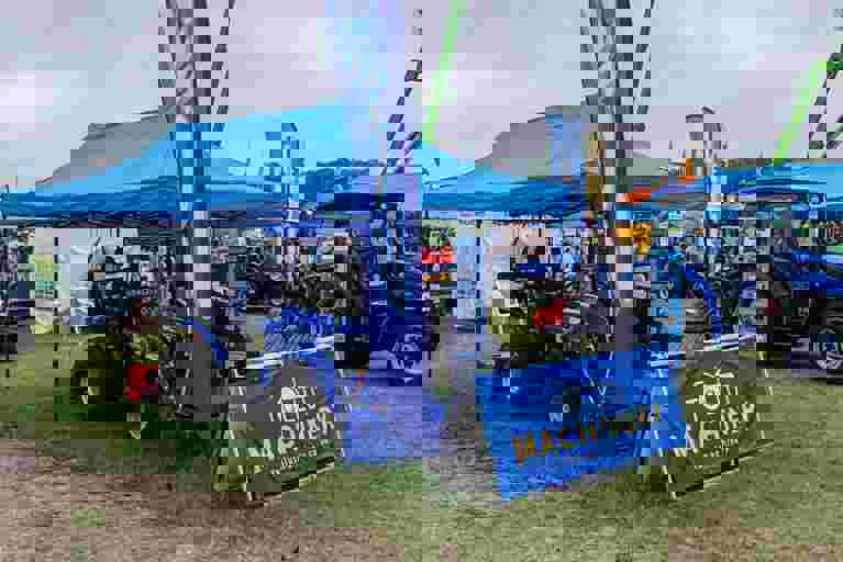 Tallut Machinery exhibition stand showcasing blue Solis tractors and equipment.